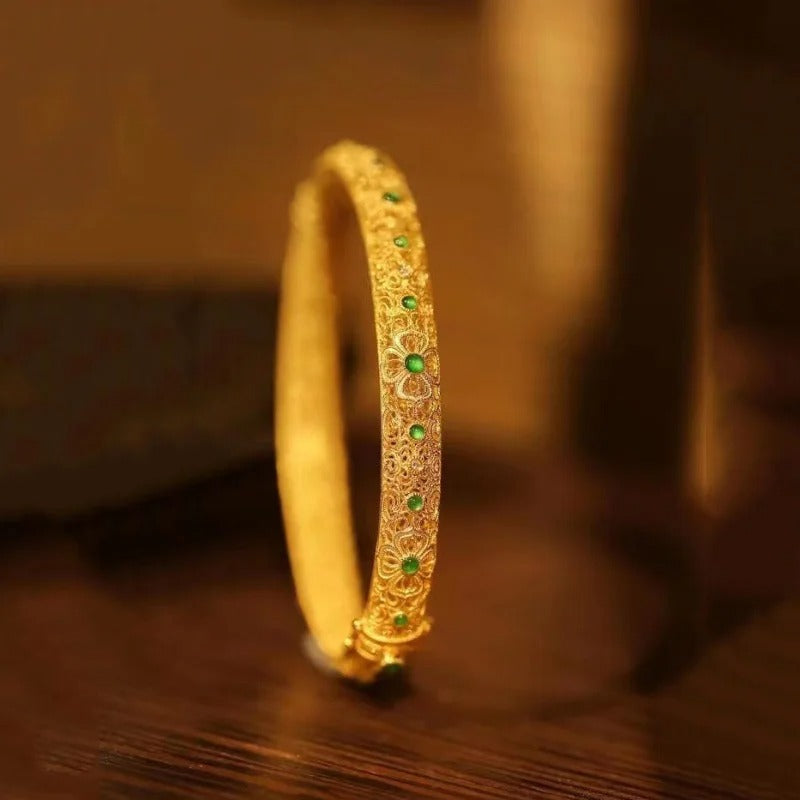 Pulseira tipo bracelete com pedras preciosas verdes douradas e padrão floral em estilo étnico